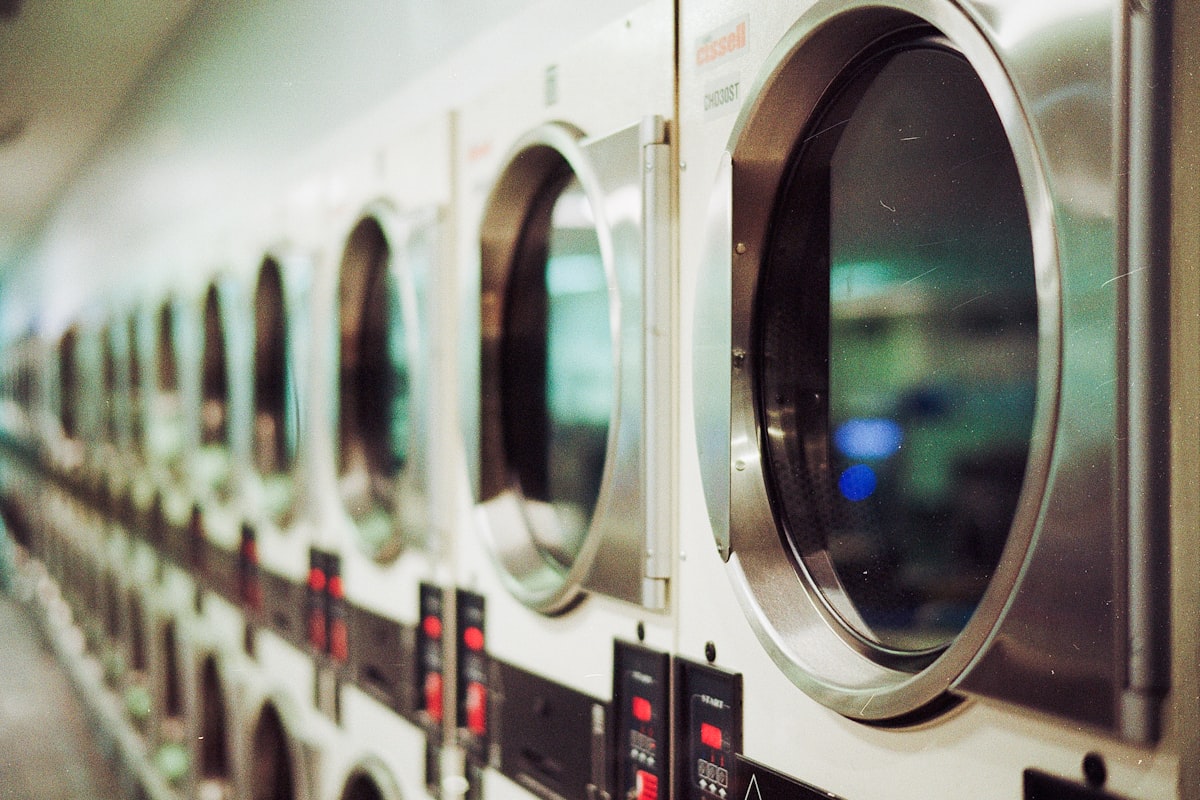 Row of commercial clothes dryers, the machines a vent line serves